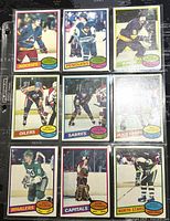 Front view of nine 1980-81 O-Pee-Chee NHL hockey player trading cards showing players in team jerseys with team names Rockies, Penguins, Kings, Oilers, Sabres, Black Hawks, Whalers, Capitals, North Stars.