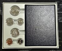 Full set of six Canadian coins in plastic capsules on white tray with black booklet.