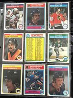 Front view of 9 assorted 1982-83 O-Pee-Chee NHL hockey player trading cards: Dwight Foster, Ted Bulley, Ron Delorme, Doug Sulliman, Paul Holmgren, Reijo Ruotsalainen, two Record Breaker cards, and one Hockey checklist card.