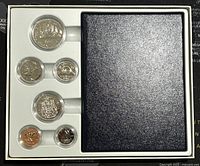 Full view of six specimen Canadian coins set inside white plastic tray with a black textured cover beside it.