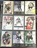 Photo of the front sides of nine different NHL hockey player trading cards arranged in a 3x3 grid within a plastic protective sleeve.