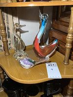 Overview photo showing all three art glass bird figures displayed on a wooden shelf.