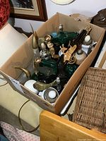 Overview of the box filled with various vintage Avon collectible bottles showing different shapes and colors.