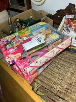 Three Barbie dolls in original rectangular packaging displayed stacked on a wooden surface.