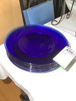 Top view showing the vibrant deep cobalt blue color and smooth glossy surface of the glass plates stacked.