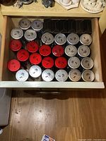 Top view of drawer filled with NHL Star Stick hockey collectible sticks with red, silver, and black caps arranged in rows.