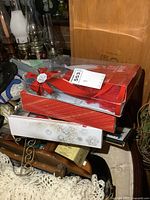 Three original boxed Holiday Barbie dolls stacked on a table with visible 2018 Holiday Barbie doll in its box.