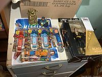 Lot overview showing all items including Black Adam figure boxed, Marvel candy dispensers, sticker books, and other figures.