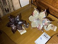 Pair of two Murano glass flowers on a wooden table with tags and acrylic stands