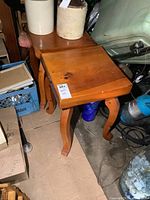 Pair of solid pine side tables stacked and viewed from above, showing the thick tops and polished wood finish with some items placed on top.
