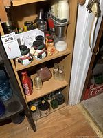 Shelf showing snowman salt and pepper shakers, gingerbread man shaker, small bottles, and Coca-Cola shaker