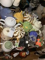 Top view of the assorted 14 teapots on a table showing various sizes and styles including Royal Doulton.