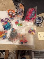 Photo showing all 10 unopened Happy Meal toys laid out including Teenage Mutant Ninja Turtles, Despicable Me 2, Muppets, and Furby characters.