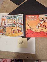Two Calvin & Hobbes books side by side on a table, showing front covers: 'Scientific Progress Goes "Boink"' and 'Weirdos From Another Planet!'.