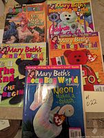 Five issues of Mary Beth's Beanie Baby World Monthly magazines spread out showing front covers with various Beanie Baby themes.