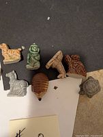 Eight small collectible porcelain Wade figurines from Red Rose Tea displayed on black and white background. Included dogs, animals, and character figures.