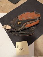Photo showing the front and interior of the Wilson Easy Catch baseball glove with visible Wilson logo and brown leather webbing.