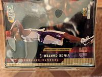 Front side of Vince Carter basketball card showing player in Toronto Raptors jersey dunking the basketball.