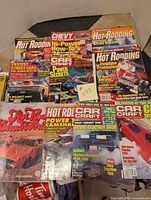 10 car magazines spread out partially overlapping, showing covers with cars, engines, and racing themes