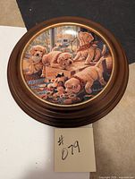 Front view of round collector plate with puppy artwork in wood frame