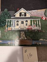Close-up of the white house with porch, steps, flower pots, and Canadian flag
