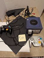 Overhead shot showing console, two controllers, power adapter, and AV cable