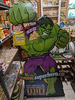 Colorful front view of Hulk cardboard display holding Lay's and Doritos chip bags, with promotional text and website.