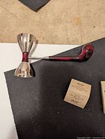 Top view of the golf club shot glass showing the wider shot cup attached to the club handle and the smaller shot cup on the opposite end.