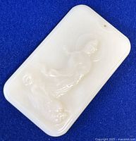 Front view of white Hetian jade ornament showing carved Guanyin figure, polished smooth surface, rounded corners, and a small hole near one corner.
