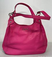 Front view of fuchsia pink leather Coach handbag with silver-tone Coach logo