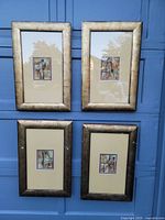 All four framed abstract paintings hung on a blue wall, showing their overall look and frames