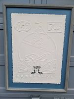 Framed embossed print showing skier and logos for IGA and 7UP with Horseshoe text