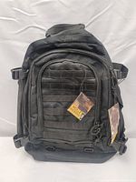 Front view of black Highland Rumble tactical backpack showing MOLLE webbing and tags.