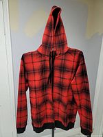 Front view of the red and black plaid full zip hoodie with hood and drawstrings.