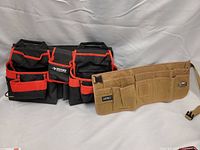 Two black Husky brand tool belts and one tan Leforz tool belt arranged on fabric background.