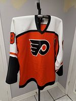 Full front view of the orange Philadelphia Flyers jersey number 88 showing logo and design details.