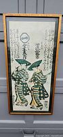 Full view of the framed print showing two women in kimono and Japanese text
