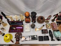 Overview of the entire lot on a white backdrop with multiple items from wood carvings, ceramic vase, boxes, and other vintage decorative pieces.