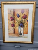 Full view of the framed painting depicting colorful tulip flowers in a glass vase with a gold frame.