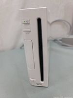 Front view of white Nintendo Wii console showing power and reset buttons, disc slot.