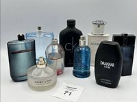 Nine assorted fragrance bottles placed together, varying in size, shape, and color with some missing caps.