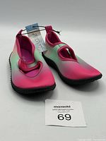Pair of girls water shoes in size 9/10 with visible tags, showing gradient colors and black gripping soles