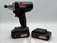 Side view of black and red Hyper Tough cordless impact driver standing on battery base next to extra 20V Max lithium-ion battery.