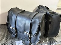 Front angle showing the left saddle bag with two buckle straps and braided edges with part of the right saddle bag behind.