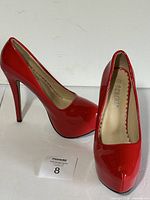 Side view of the red platform high heel dress pumps, showing the heel height and glossy finish.