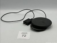 Samsung wireless charger laid flat showing power adapter and cable attached.