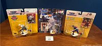 Photo of three Starting Lineup sports figures in packaging: two hockey and one baseball figure on a blue background.