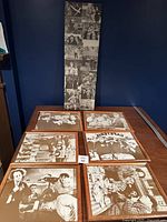 Five framed black and white photos of The 3 Stooges showing different scenes and poses on a wooden table.