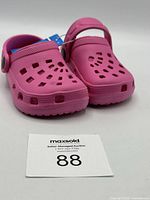 Front view of the pink toddler shoes showing ventilated holes and original tag attached. Size 5/6.