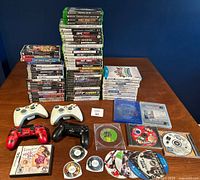 Overview of all game cases, loose discs and controllers on table